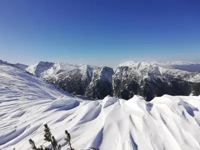 a view of snow covered mountains in the distance at Апартамент - Боровец Хотел ''Боровец Гардънс'' A 44 in Borovets