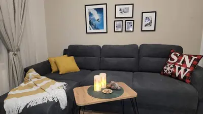 a living room with a couch and a table with candles at Arboro Borovets Gardens E68 in Borovets