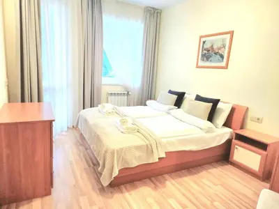 a bedroom with a large bed with white sheets at Arboro Royal Plaza in Borovets