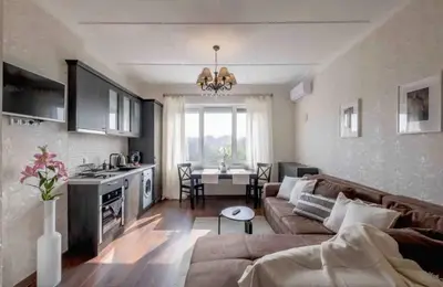 a living room with a couch and a kitchen with a table at Budget Stay in City Center near NDK in Sofia