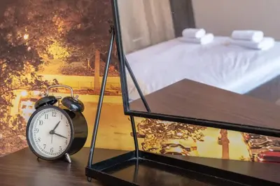 a clock sitting on a table next to a bed at Budget Stay in City Center near NDK in Sofia