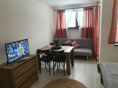 a small living room with a table and a couch at Апартамент B9 in Borovets