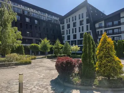 a courtyard with trees in front of a building at Студио Пацо и Нина в AspenValley in Razlog