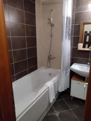 a bathroom with a bath tub and a sink at Студио Пацо и Нина в AspenValley in Razlog