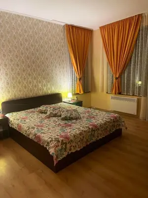 a bedroom with a bed and two windows with curtains at SNOW PEAK TODORKA APARTAMENT /NEXT TO THE LIFT/ 6 PERSONS in Bansko