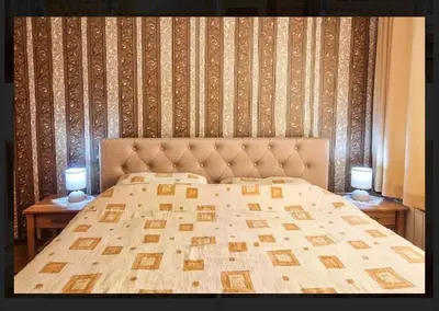 a bedroom with a bed with two candles on tables at Къща за гости Карасански in Bansko
