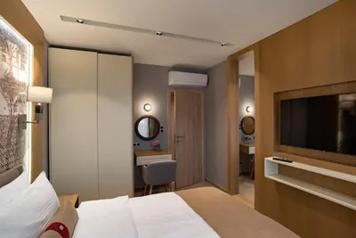 a hotel room with a bed and a television at City Park Inn Apartment Cortona in Plovdiv