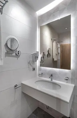 a white bathroom with a sink and a mirror at City Park Inn Apartment Cortona in Plovdiv