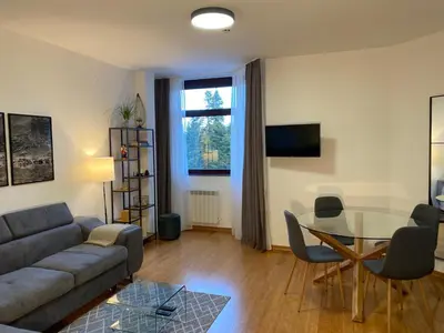 a living room with a couch and a glass table at Sana Ski apartment 620 in Flora, Borovets in Borovets