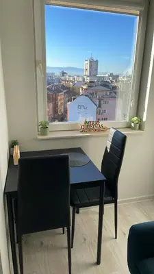 a table and two chairs in a room with a window at Amazing view central 1 bedroom apartment in Pazardzhik