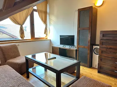 a living room with a coffee table and a tv at Snow Legend private apartments in Bansko