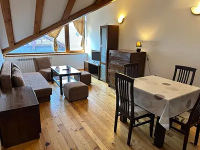 a living room with a table and chairs at Snow Legend private apartments in Bansko