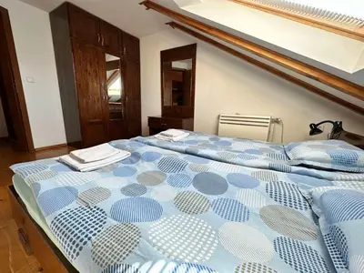 a bedroom with a large bed with a blue comforter at Snow Legend private apartments in Bansko