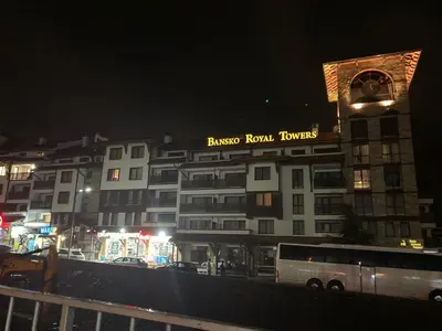 a building with a clock tower on top of it at night at Studio Stankovic Royal Towers 326 in Bansko