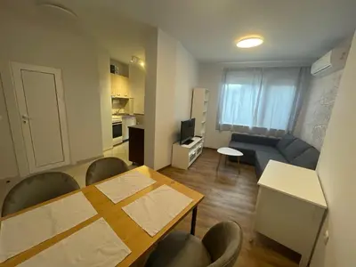 a living room with a table and chairs and a kitchen at Top Center 2-BR Apartment with lovely Outdoor Area in Plovdiv