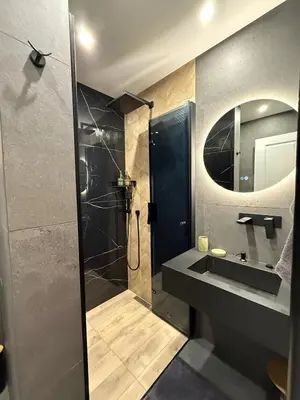 a bathroom with a shower and a sink and a mirror at Ski Bansko Design Apartments in Bansko