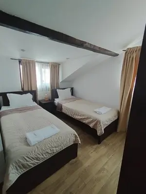a bedroom with two beds and a window at Къща за гости - Вила Сидона in Banya