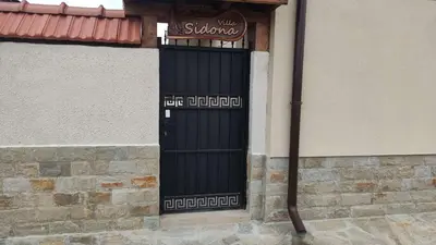 a black door on the side of a building at Къща за гости - Вила Сидона in Banya