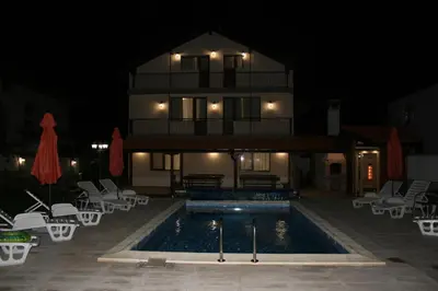a house with a swimming pool at night at Къща за гости - Вила Сидона in Banya