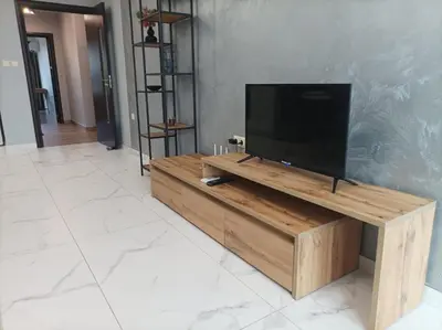 a flat screen tv sitting on top of a wooden entertainment center at One Bedroom Apartment 37- Trakia 54 А in Plovdiv