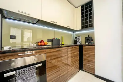 a kitchen with wooden cabinets and a stainless steel appliance at Secluded Mountain Cozy Studio with Fireplace in Bansko