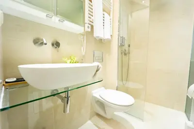 a white bathroom with a toilet and a sink at Secluded Mountain Cozy Studio with Fireplace in Bansko