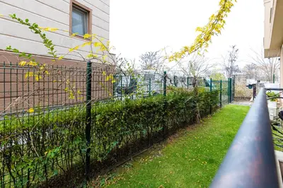 a fence with bushes next to a building at Bright & Cozy 1BD Flat with a Terrace and Parking by Flat Mаnager in Plovdiv
