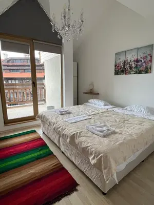 a bedroom with a large bed with a colorful rug at Penthouse Harriet Bansko in Bansko