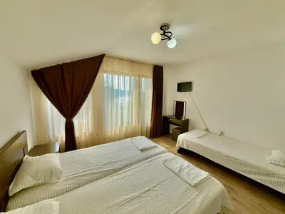 a bedroom with two beds and a window at Къщи за гости Фантазия in Dospat