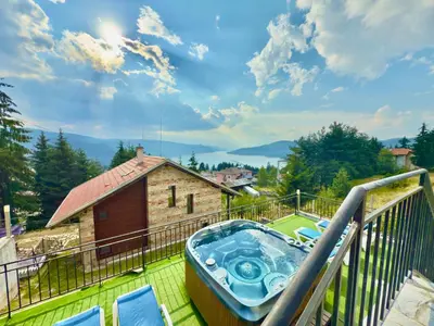 a hot tub on the balcony of a house at Къщи за гости Фантазия in Dospat