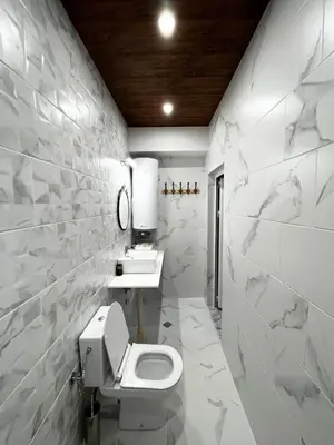 a white bathroom with a toilet and a sink at Roots Apartment 2 in Borovets