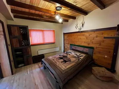 a bedroom with a bed and a wooden wall at Roots Apartment 2 in Borovets