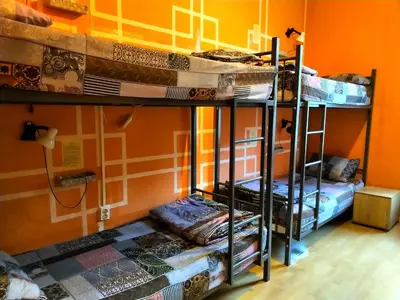 two bunk beds in a room with an orange wall at 