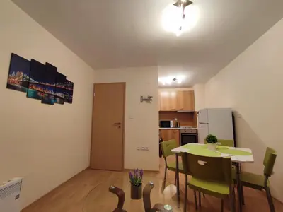 a dining room and kitchen with a table and chairs at Pirin Sunrise in Bansko