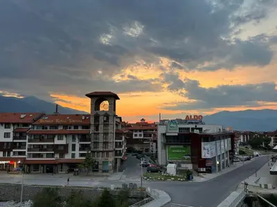 a clock tower in the middle of a city at Gondola lift apartment in Bansko