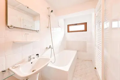 a white bathroom with a sink and a bath tub at Хотел Феникс in Chepelare