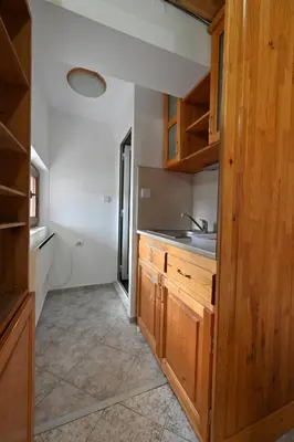a kitchen with wooden cabinets and a sink at Хотел Феникс in Chepelare