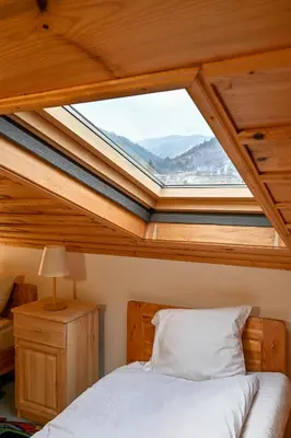 a bed in a room with a skylight at Хотел Феникс in Chepelare