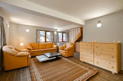 a living room with two couches and a staircase at Хотел Феникс in Chepelare