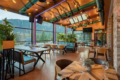 a restaurant with tables and chairs and large windows at 103 View Park Hotel in Panichishte
