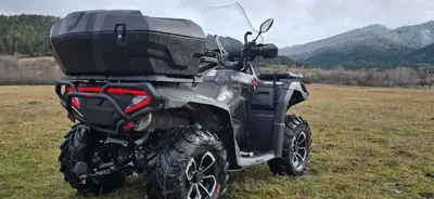 a atv parked in a field with mountains in the background at Апартамент Edelweiss in Beli Iskar