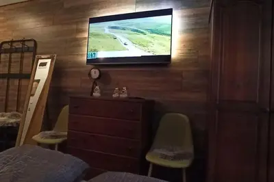 a bedroom with a television on a wall with chairs at Апартамент Edelweiss in Beli Iskar