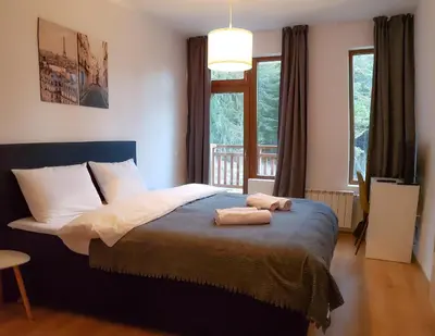 a bedroom with a bed with two towels on it at Semiramida Garden Apartment 12 in Borovets