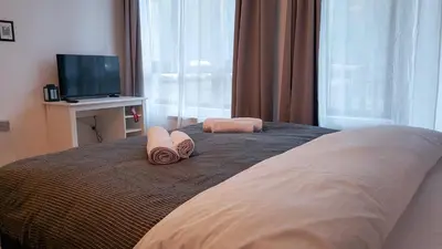a bedroom with a bed with two pillows and a television at Semiramida Garden Apartment 12 in Borovets