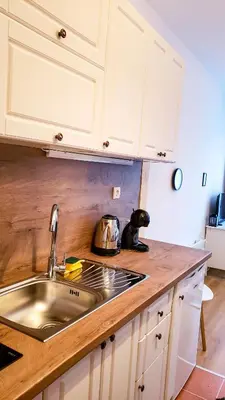 a kitchen with white cabinets and a sink at Semiramida Garden Apartment 12 in Borovets