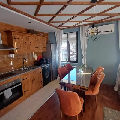 a kitchen with a table and chairs in a room at Mila VIP Apartment in Bansko