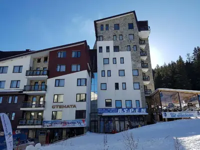 two tall buildings next to each other in the snow at Студио, хотел Стената in Pamporovo
