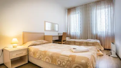 a bedroom with two beds and a desk and a computer at Студио, хотел Стената in Pamporovo