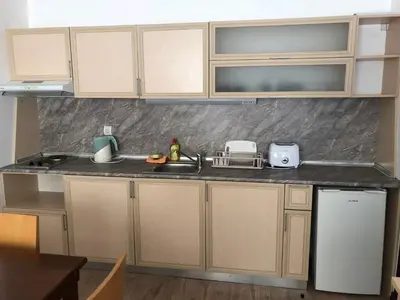a kitchen with white cabinets and a counter top at Студио, хотел Стената in Pamporovo
