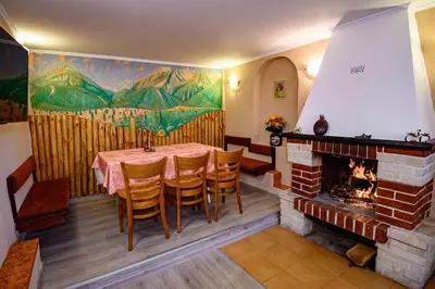 a dining room with a table and a fireplace at Lalev Guest House in Bansko